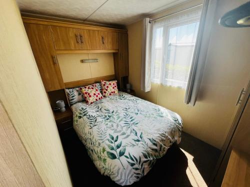 a small bedroom with a bed and a window at 22 seabreeze holiday park in Hemsby