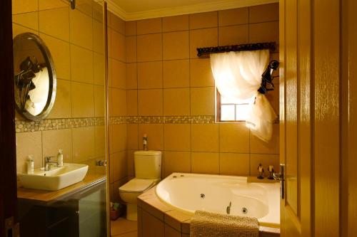 a bathroom with a tub and a toilet and a sink at Skilpadvlei Cottage and Studio's in Velddrif