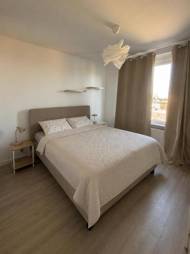 a white bedroom with a large bed and a window at The North Antwerp Apartment in Antwerp