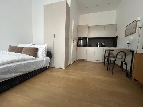 a bedroom with a bed and a table and a kitchen at Apartament Mini Stary Sącz in Stary Sącz