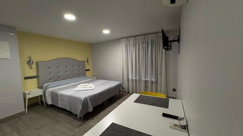 a small bedroom with a bed and a table at Alojamientos Templete in Caravaca de la Cruz