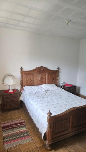 a bedroom with a large bed with a wooden frame at Recanto do majo in Petrópolis