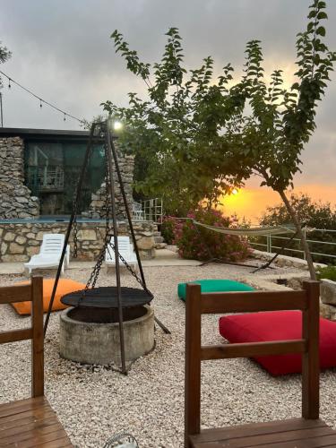 a swing in a backyard with the sunset in the background at Fannoun Getaway Lodge by Hansa in Ḩayy al Qal‘ah