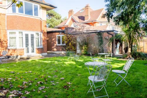 a yard with chairs and tables in front of a house at Cransley in Bournemouth