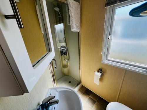 a small bathroom with a sink and a window at 22 seabreeze holiday park in Hemsby