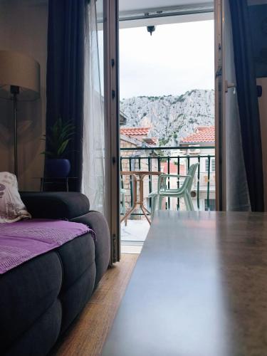 a living room with a couch and a balcony at Apartman Brzović in Omiš