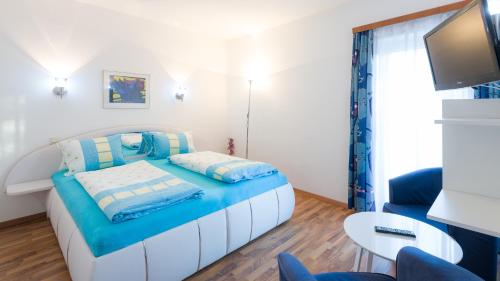 a small bedroom with a bed and a tv at Apartments Presslauer - Mori in Sankt Kanzian