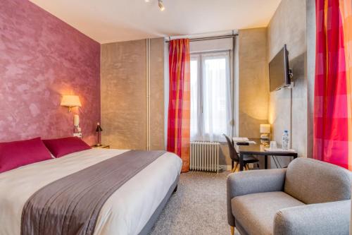 a hotel room with a bed and a chair and a desk at Brit Hotel le Cygne in Saint-Hilaire-du-Harcouët
