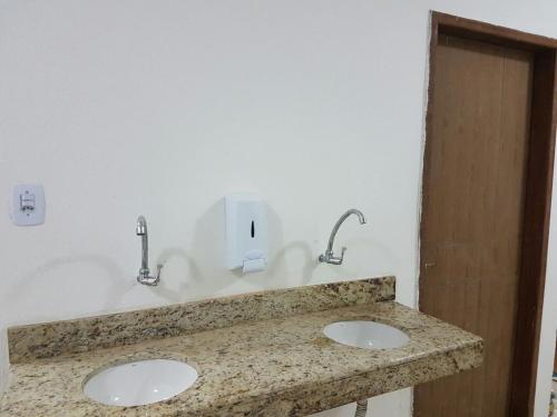 a bathroom with two sinks and two faucets at Casa de Arigoffe in Salvador