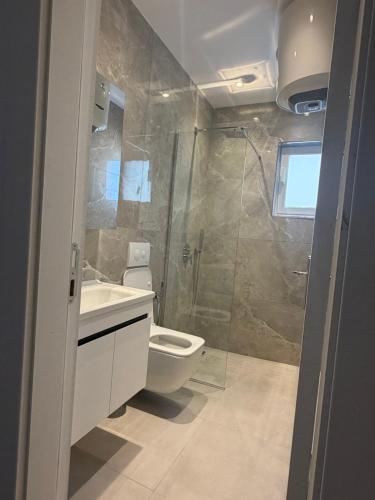 a bathroom with a shower and a toilet and a sink at Durres Beach Rooms in Durrës