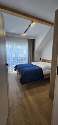 a bedroom with a bed and a large window at Sarbinowo Lazur Spokojna in Sarbinowo