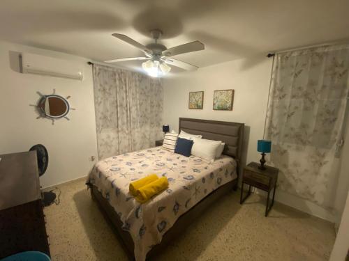 a bedroom with a bed with a ceiling fan at Cozy Beach Apartment in Luquillo