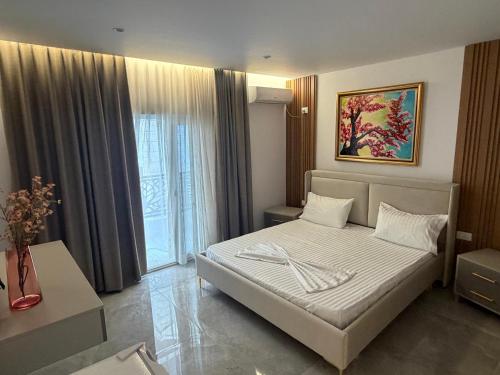 a bedroom with a bed and a large window at Durres Beach Rooms in Durrës