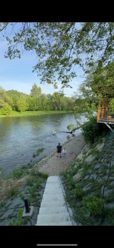 a person with an umbrella walking on the shore of a river at Osada pod Sokolicą in Krościenko