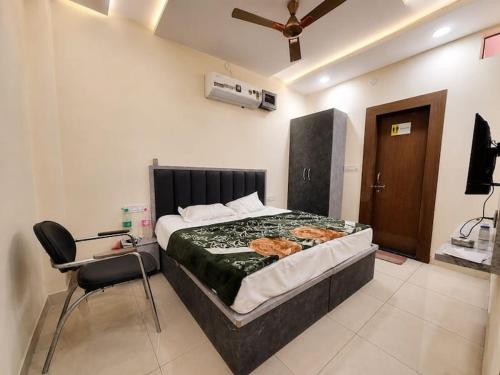 a bedroom with a bed and a desk and a chair at HotelTree in Hisār