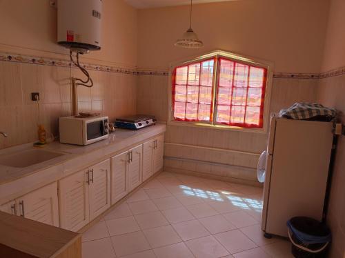 a kitchen with a sink and a microwave at Dar Pikhasa in Saïdia