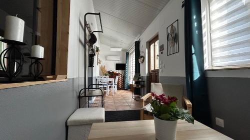 a hallway with a stairway with a vase of flowers at Gite du Tacot 21 in Saulieu