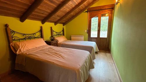a bedroom with two beds and a window at Casa Rural GABARDA in Aso de Sobremonte