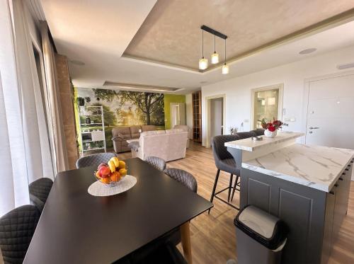 a kitchen and living room with a table and chairs at Villa Dobric Apartments in Kavač