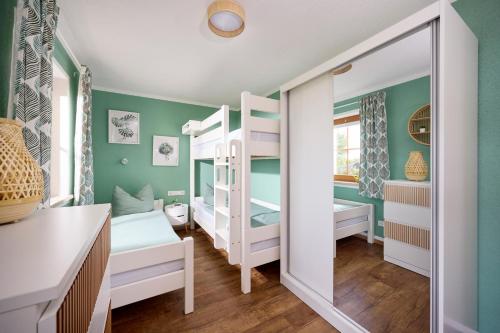 a bedroom with two bunk beds and a mirror at Ferienwohnung Nähe Dresden mit Pool & Spielplatz - FeWo "Waldblick" und "Gartenblick" an der Talsperre Malter in Dippoldiswalde