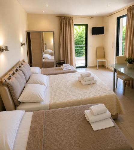 a hotel room with two beds with towels on them at Hotel Olivia in Agiokampos
