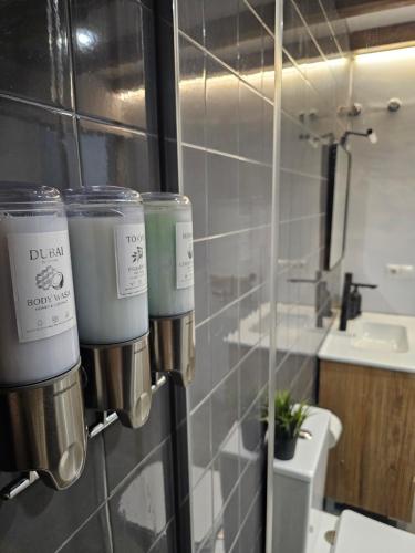 a bathroom with three cups on the wall at Bear Homes - Olimpia Suite in Valencia