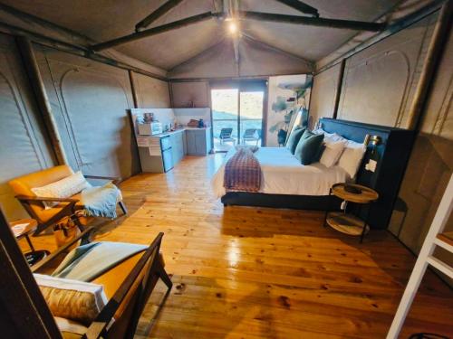 a bedroom with a large bed in a tent at Oudemuur Glamping in Montagu