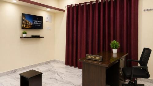 a conference room with a desk and a red curtain at Hotel O Boby Royal Palace in Pratāpgarh