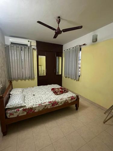 a bedroom with a bed and a ceiling fan at ChriSeph in Kottayam