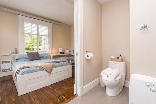 a bedroom with a bed and a desk and a toilet at Les Suites Du Vieux-Lévis - With AC and Parking in Lévis