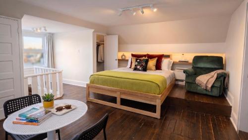 a bedroom with a bed and a table and a chair at Les Suites Du Vieux-Lévis - With AC and Parking in Lévis
