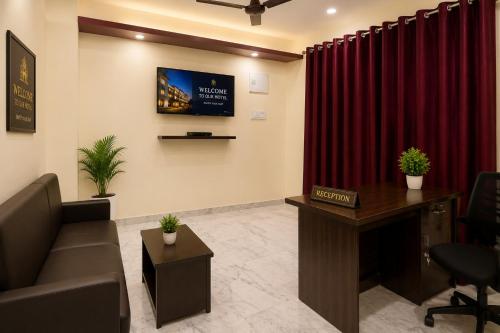 a waiting room with a couch and red curtains at Hotel O Boby Royal Palace in Pratāpgarh