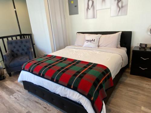 a bedroom with a bed with a blanket and a chair at Soundview Ferry Cottage in Mukilteo