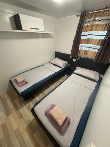 two beds in a small room with a window at Villa Renata in Pirovac