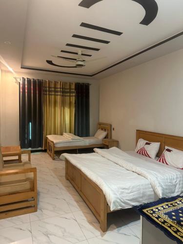 a hotel room with two beds and a room with two chairs at Comfort Inn in Kalām