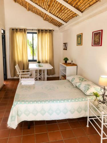 a bedroom with a bed and a table and a desk at Hotel Aguablanca in La Mesa
