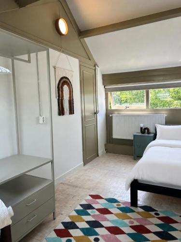 a bedroom with a bed and a book shelf at De Strandjutter in Warmenhuizen