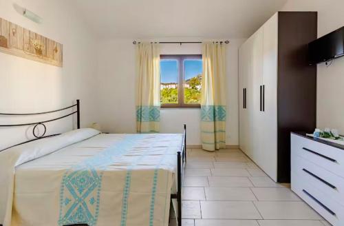 a bedroom with a large bed and a window at Il Girasole - Appartaments in Domus de Maria