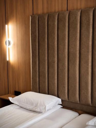 a bed with two pillows in a room with a window at Hotel Paradise in Ognyanovo