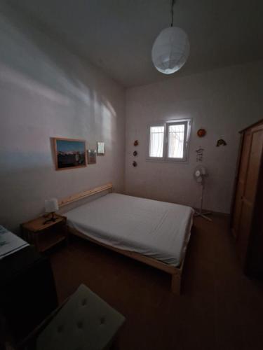 a bedroom with a large bed and a window at Villino Irmgard in Butera