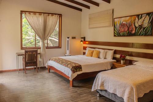 a hotel room with two beds and a window at Villa Lu Amazon Ecolodge in Tarapoto