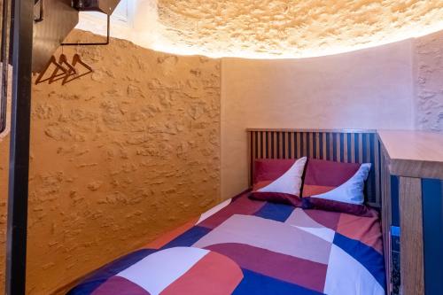 a bedroom with a bed with colorful pillows at Moulin insolite - Rooftop - Proche St-Emilion in Saint-Vincent-de-Pertignas