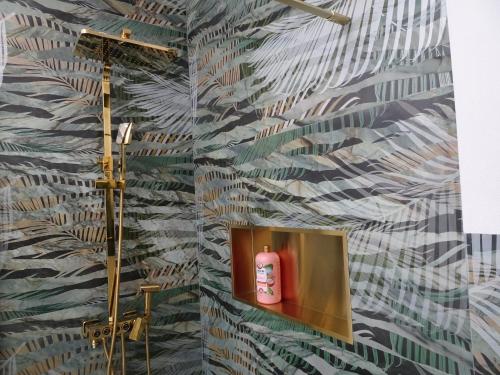 a bathroom with a wallpaper with a pink soap dispenser at Carma de Madeira Lodge in Penela