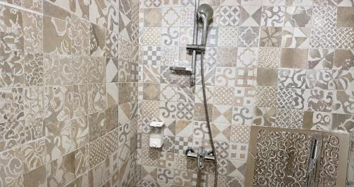 a shower in a bathroom with a tile wall at Park and Fly Belgrade Airport Apartments in Surčin