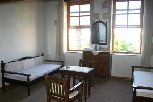 sala de estar con sofá, mesa y ventana en Oasis Guesthouse, en La Canea