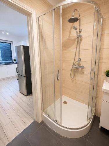 a shower stall in a kitchen with a refrigerator at Ametystowa Street in Września