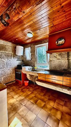 a kitchen with a sink and a wooden ceiling at Border Bridge House in Tui