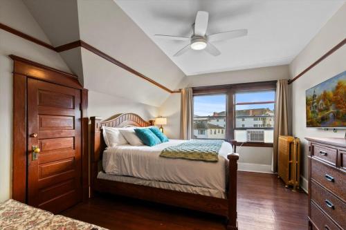 a bedroom with a bed with a ceiling fan and a window at Stonehurst Estate Sleep 16 in Chilliwack