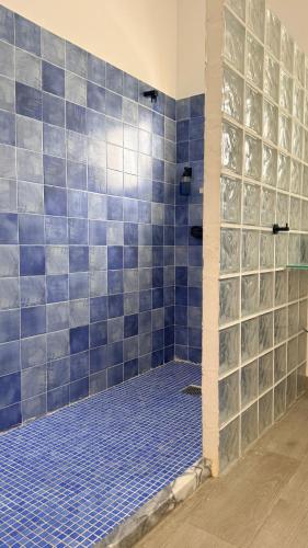 a bathroom with a shower with blue tiles at O Tourinho Ferrel in Ferrel