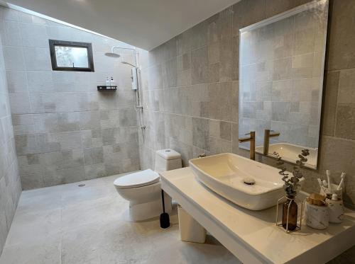 a bathroom with a sink and a toilet at The Arya Srithanu in Ko Kong Nui